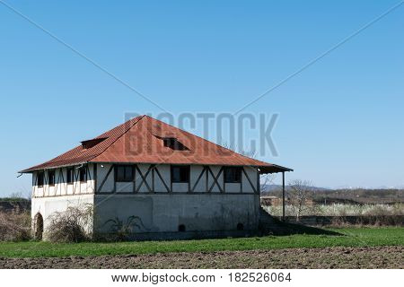 single plain house with interesting wood beams walls and hills in the background. exterior photograph