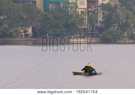 Fisherman at Truc Bach lake cityscape Hanoi Vietnam