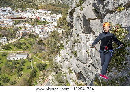 Woman hanging on Tibetan bridge climbing up to the hill. Horizontal outdoors shot