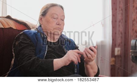 Old Woman pensioner speaks on cell phone, telephoto, cllose up