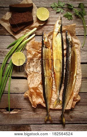 Fish saury smoked on paper and wooden boards