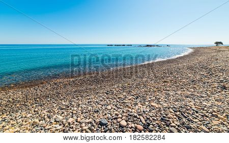 Blue sea and pebbles in Baccu e Praidas beach Sardinia