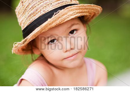 Girl in a straw hat in the park