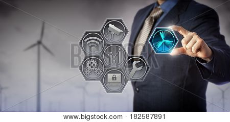 Blue chip business manager monitoring and controlling wind farm infrastructure via an internet of things application matrix. Renewable energy and Internet of Things concept for wind farm management.
