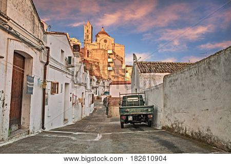 PISTICCI, MATERA, ITALY - MARCH 11: alley in the old town with the typical houses and the ancient mother church in the background. Photo taken on March 11, 2017 in Pisticci, Matera, Basilicata, Italy