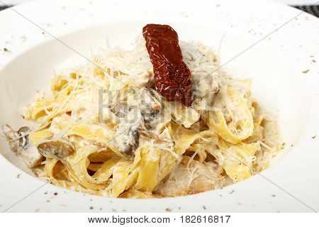 Pasta in white sauce with mushrooms and parmesan cheese isolated on white background