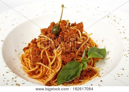 Pasta with meat, tomato sauce, parmesan and vegetables isolated on white background