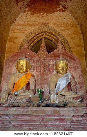 Two old Buddha statues sitting in meditation in Dhammayangyi pagoda in Bagan Myanmar.
