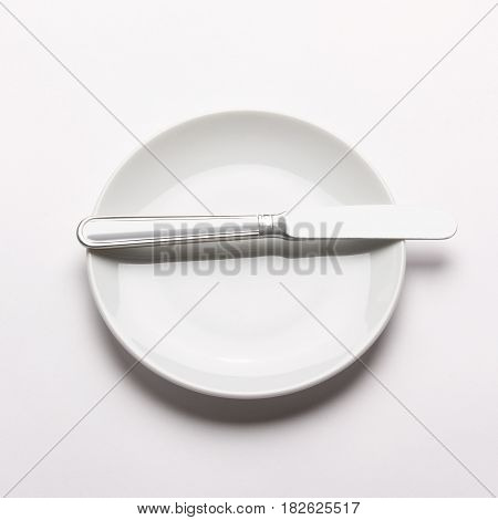 White plate and knife on white background