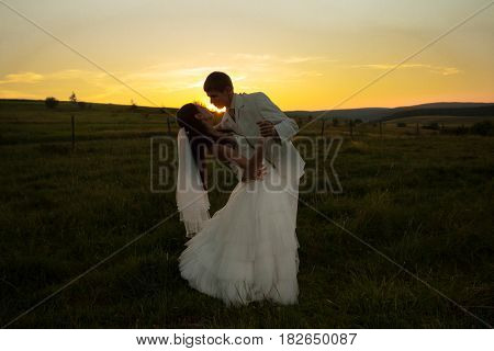 Wedding couple is dansing on the sunset