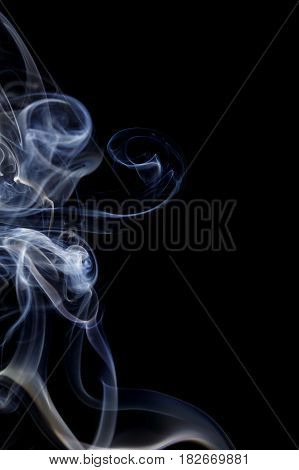 Abstract art. Color white blue smoke from the aromatic sticks on a black background. Background for Halloween. Texture fog. Design element. The concept of aromatherapy.
