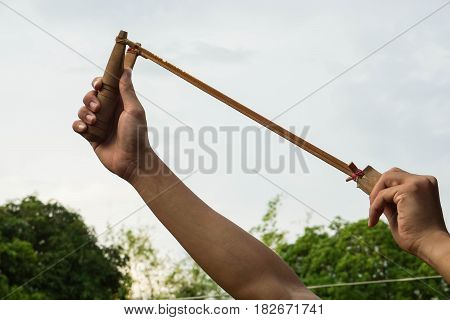 close up man use slingshot for insects and bird hunting in rural area