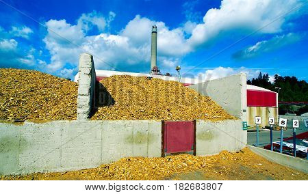 Bio Power Plant With Storage Of Wooden Fuel Against Blue Sky