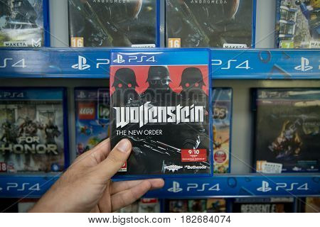 Bratislava, Slovakia, circa april 2017: Man holding Wolfenstein The new order videogame on Sony Playstation 4 console in store