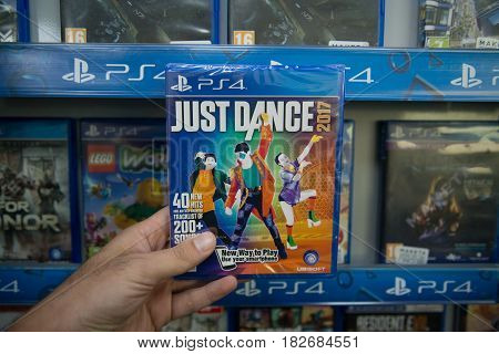 Bratislava, Slovakia, circa april 2017: Man holding Just Dance 2017 videogame on Sony Playstation 4 console in store