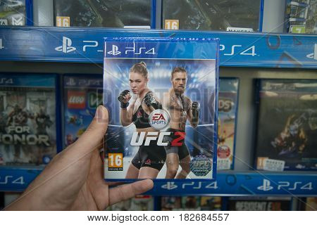 Bratislava, Slovakia, circa april 2017: Man holding UFC 2 videogame on Sony Playstation 4 console in store