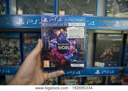 Bratislava, Slovakia, circa april 2017: Man holding Playstation Worlds VR videogame on Sony Playstation 4 console in store