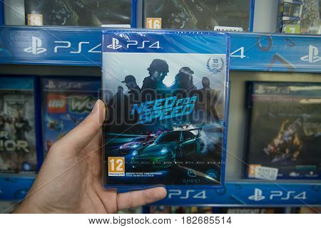 Bratislava, Slovakia, circa april 2017: Man holding Need for Speed videogame on Sony Playstation 4 console in store