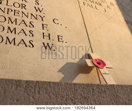 IEPER, BELGIUM, APRIL 8 2017: A poppy memorial cross left poignantly at the Menin Gate in Ypres, lit by a low evening sun. The Menin gate is a focal point for first world war remembrance.