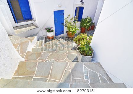traditional cycladic yard with blue windows and flowers at Apollonia Sifnos Greece