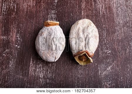 Dried persimmon fruits on dark brown background