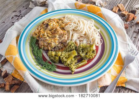 Pasta with chicken and vegetables on a dark wood in a rustic style
