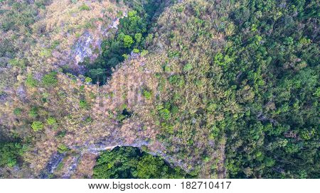 aerial photography above amazing cave. Tham Than Lod Yai is the big cave and have one hole on the top of the cave. it is a short cave there have waterfall pass inside through to another cave