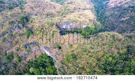 aerial photography above amazing cave. Tham Than Lod Yai is the big cave and have one hole on the top of the cave. it is a short cave there have waterfall pass inside through to another cave