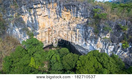 aerial photography above amazing cave. Tham Than Lod Yai is the big cave and have one hole on the top of the cave. it is a short cave there have waterfall pass inside through to another cave