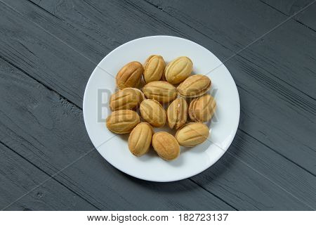 Homemade cookies with condenced milk on a white plate, top view