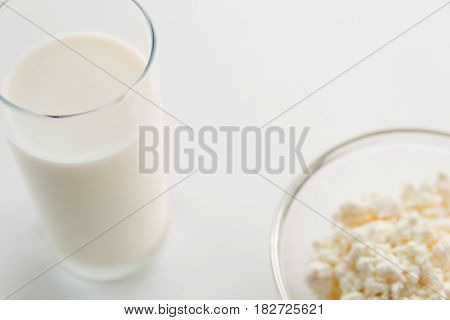 Milk In A Glass, Cottage Cheese In A Bowl, On A White Table, In A High Key, Close-up With Place For