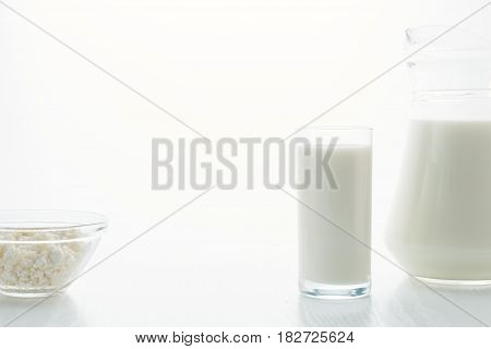 Milk In A Glass, Cottage Cheese In A Bowl, On A White Table, In A High Key, Close-up With Place For