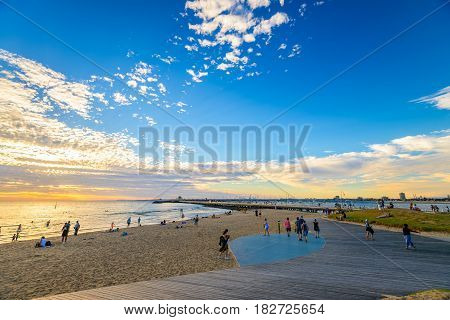 Melbourne Australia - December 28 2016: People spending time on St. Kilda Beach at sunset on a hot summer day Victoria Australia