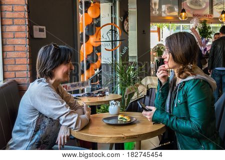 Eskisehir Turkey - April 15 2017: People enjoy eat and drinks in the opening of Krepya Cafe. Two young women sitting at a cafe table.