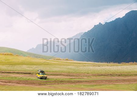 Yellow SUV Car On Off Road In Spring Mountains Landscape In Georgia. Drive And Travel Concept. Landscape Of Gorge At Spring Season.