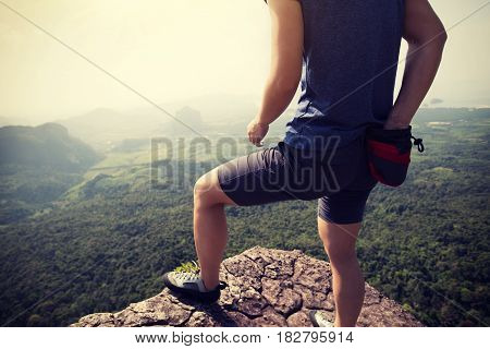 success young woman rock climber on mountain peak