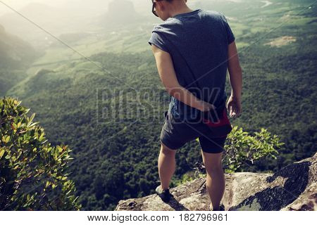success young woman rock climber on mountain peak