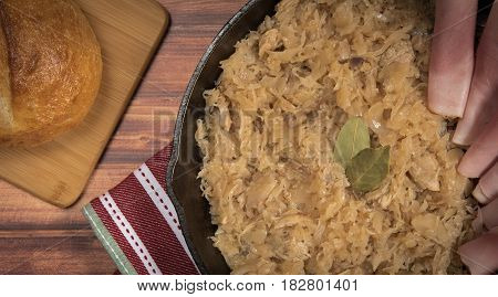 homemade braised sauerkraut in a frying pan on a wooden background