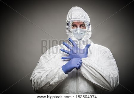 Man With Intense Expression Wearing HAZMAT Protective Clothing Against A Gray Background.