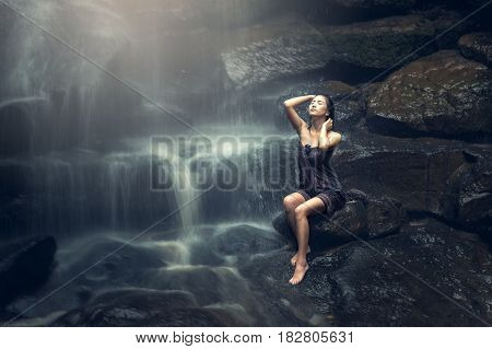 Beautiful Asian woman in waterfall, countryside of Thailand