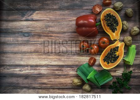 Top view of fresh vegetables fruits nuts. Wooden texture background with copy space.