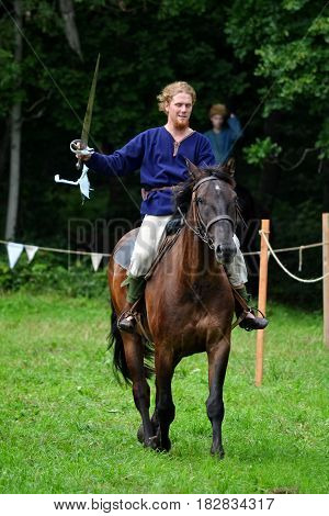 TERVETE LATVIA - AUGUST 13 2011: Historical Zemgalu days. Unknown rider on horseback in ancient clothing with ancient weapons.