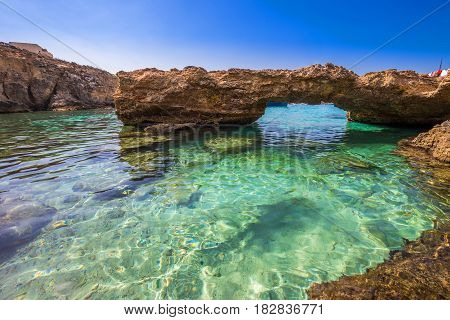 Blue Lagoon Malta - The arch of the Blue Lagoon on the island of Comino on a bright sunny summer day with blue sky