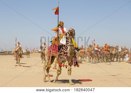 JAISALMER INDIA - FEBRUARY 09 2017 : Camel and indian men wearing traditional Rajasthani dress participate in Mr. Desert contest as part of Desert Festival in Jaisalmer Rajasthan India