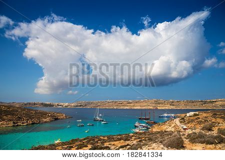 Blue Lagoon Malta - Beautiful clouds over malta's famous Blue Lagoon on the island of Comino with the island of Gozo and Mgarr town at the background on a bright sunny summer day