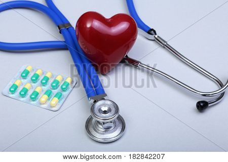 RX prescription, Red heart, asorted pils and a stethoscope on white background.
