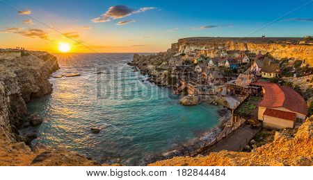 Il-Mellieha Malta - Panoramic view of the famous Popeye Village at Anchor Bay at sunset