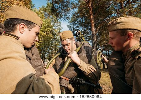 Dyatlovichi, Belarus - October 1, 2016: Reenactor Man Dressed As Russian Soviet Red Army Infantry Soldier Of World War II Preparing For Marching In Forest With Machine-gun At Historical Reenactment