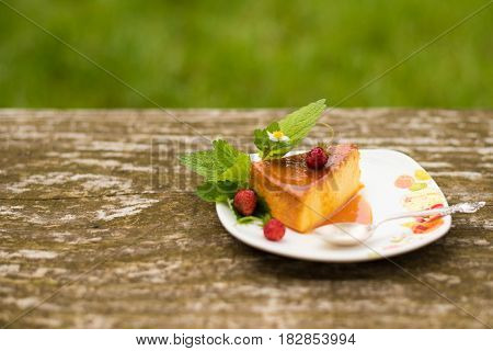 Slice of Milk Pudding with mint and strawberries over a wooden table. Brazilian Flan. French creme caramel dessert or flan with ingredients at the background. Custard pudding