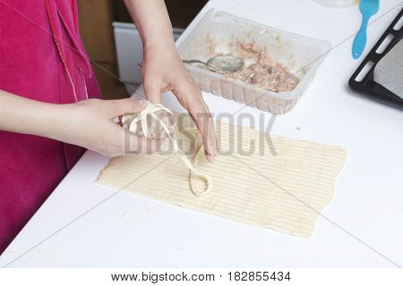 Preparation Of Meat Glomeruli. Stuffed Turkey, Wrapped In Strips Of Puff Pastry. A Woman Winds A Str